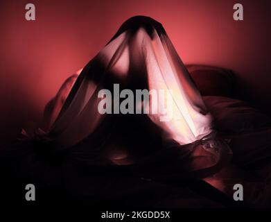 Depression, Angst und Rot mit einer Frau im Bett, allein mit ihren Gedanken, während sie unter einer Decke saß. Stress, Angst und ein schlafloses Schlafzimmer Stockfoto