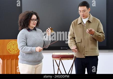 (221123) -- TIANJIN, 23. November 2022 (Xinhua) -- Amiris Rodrigues Barros (L) erlernt den „Jingdong Dagu“ von ihrem Meister Wang Wenlei in einem Klassenzimmer der Nankai-Universität in Nordchina in Tianjin, 20. November 2022. Amiris Rodrigues Barros, ein brasilianisches Mädchen, das für einen Master-Abschluss an der Nankai University in Nordchina Tianjin arbeitet, hat eine faszinierende Liebe zur traditionellen chinesischen Kultur. Zum ersten Mal hing sie an China, als sie noch auf der Highschool in ihrer Heimat war, wo sie chinesische Kurse besuchte und besonderes Interesse an chinesischer Küche und interessanten Orten wuchs. Später hat sie sc Stockfoto