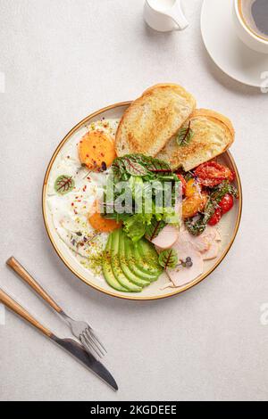 Frühstück mit Spiegeleiern mit Salat und Avocado Stockfoto
