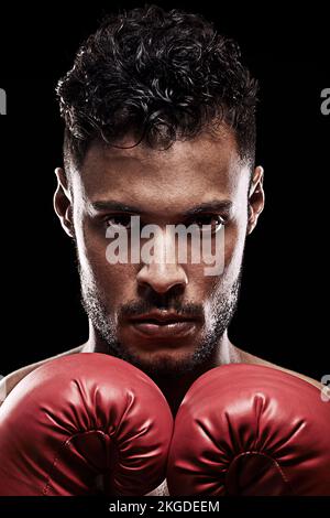 Erkenne dich selbst und du wirst alle Schlachten gewinnen. Porträt eines jungen Mannes mit Boxhandschuhen vor schwarzem Hintergrund. Stockfoto
