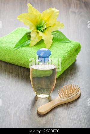 Flasche Haarbürste Handtuch und Blume Stockfoto