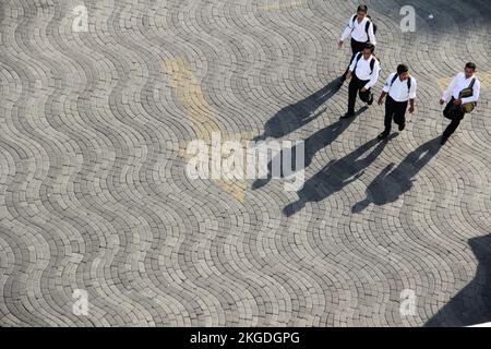 Leute, die an sonnigen Tagen mit Schatten auf der Straße laufen, auf dem Foto von der Spitze des Gebäudes. (Surabaya, Indonesien - 27. Oktober 2018) Stockfoto