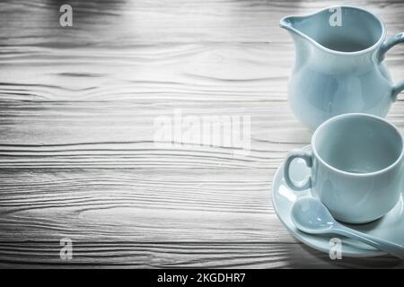 Keramiktasse Untertasse Teelöffel Creamer auf Holzbrett. Stockfoto