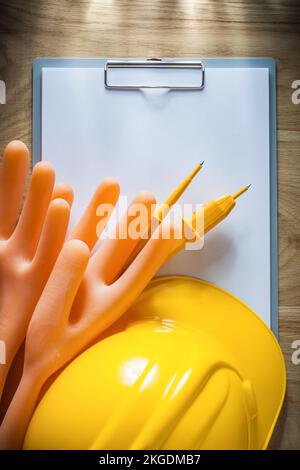 Klemmbrett Papier dielektrische Handschuhe Schutzhelm elektrischer Tester auf Holzbrett. Stockfoto