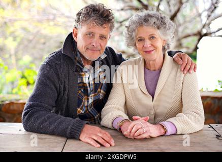 Wir verbringen einen entspannten Morgen zusammen. Porträt eines liebevollen Seniorenpaares, das an einem Tisch im Freien sitzt. Stockfoto