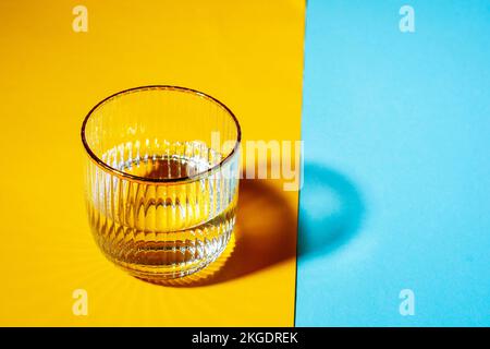 Brille mit Wasser auf zweifarbigem Hintergrund mit Kopierbereich Stockfoto