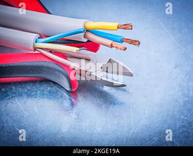 Elektrokabel Drähte Schneidezange auf metallischem Hintergrund Konzept. Stockfoto