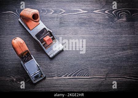 Flache, von Hand rasierende Oldtimer-Hobel auf Holzbrett. Stockfoto