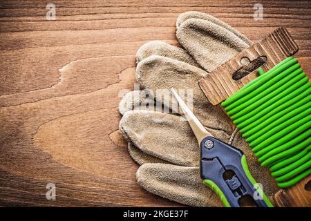 Gartenschnur schert Schutzhandschuhe auf Holzbrettern Gartenkonzept. Stockfoto