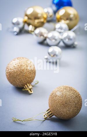 Goldfarbene weihnachtsbälle auf grauem Hintergrund Stockfoto