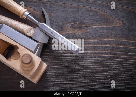 Horizontale Ausführung von Rasierhobel mit Klauenhammer und Meißeln auf altem Holzbrettbaukonzept. Stockfoto