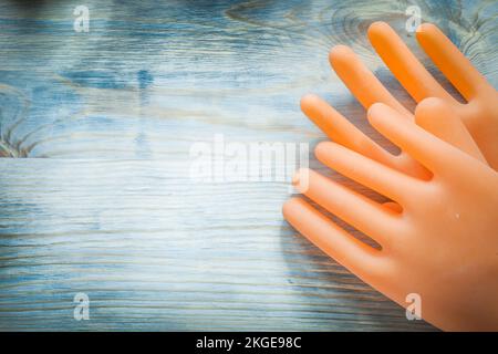 Isolierhandschuhe auf Holzplatte Kopierraum-Stromkonzept. Stockfoto