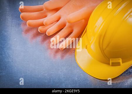Isolierhandschuhe aus Gummi Bauhelm auf metallischem Hintergrund Elektrokonzept. Stockfoto