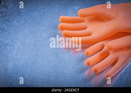 Ein Paar dielektrische Gummihandschuhe zum metallischen Hintergrundstromkonzept. Stockfoto