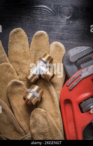 Rohrzange Sanitärarmaturen Lederschutzhandschuhe auf Holzplatte. Stockfoto