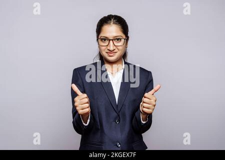 Schöne junge elegante Frau über isolierte Hintergrund erfolg Zeichen tun positive Geste mit der Hand, Daumen hoch am lächeln und glücklich. Ein Blick auf die kam Stockfoto