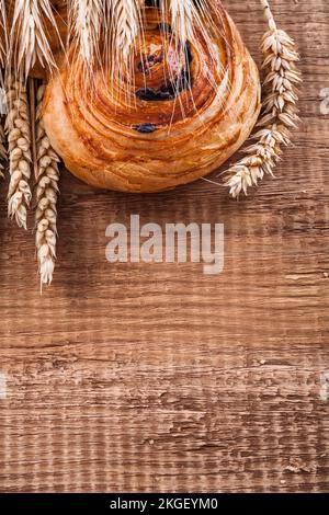 Reife Weizenohren reichhaltiges Rosinenbrötchen auf Eichenholzbrett Speisen und Getränke Konzept Stockfoto