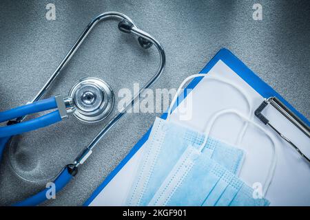 Stethoskop Clip Board Sterile medizinische Masken auf grauem Hintergrund. Stockfoto