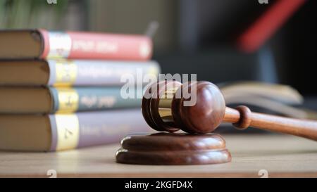 Beurteilen Sie Hammer oder Hammer auf dem Tonblock und Stapel von Gesetzesbüchern auf dem Tisch Stockfoto