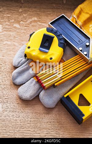 Maßeinheiten und Schutzhandschuh auf Eichenbrettbaukonzept Stockfoto