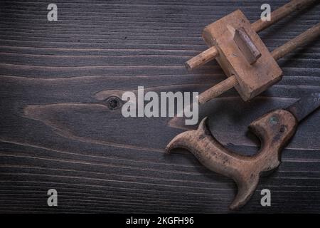 Verrostete Handsäge aus Holz mit Holzoberflächenmaß im Vintage-Stil. Stockfoto