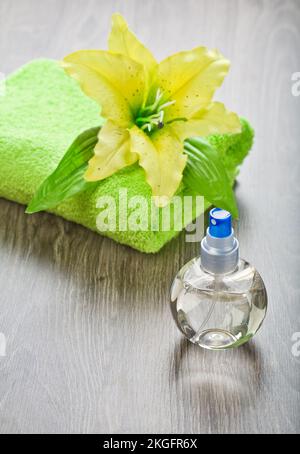 gelbe Blume auf Handtuch und durchsichtige Flasche Stockfoto