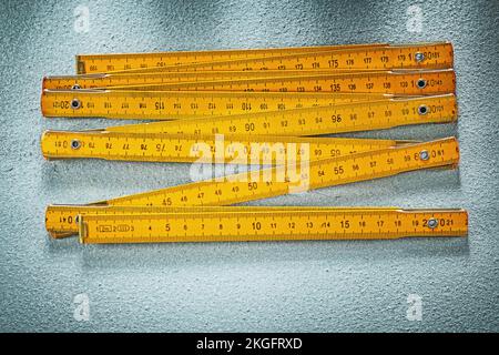 Gelbes Holzmessgerät auf Betonoberfläche Baukonzept. Stockfoto
