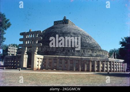 Sanchi ist ein buddhistischer Komplex, berühmt für seine große Stupa, auf einem Hügel in der Stadt Sanchi im Bezirk Raisen im Bundesstaat Madhya Pradesh, Indien. Die große Stupa in Sanchi ist eine der ältesten Steinbauten und ein wichtiges Denkmal der indischen Architektur. Es wurde ursprünglich vom maurischen Kaiser Ashoka dem Großen im 3.. Jahrhundert BCE in Auftrag gegeben. Es wurden vier kunstvoll geschnitzte Toranen (dekorative Tore) und eine Balustrade hinzugefügt, die die gesamte Struktur umgibt. Die Sanchi Stupa, die während der Mauryanzeit erbaut wurde, war aus Ziegeln. Sanchi Stupa steht für seine Bedeutung für das indische Kulturerbe. Stockfoto