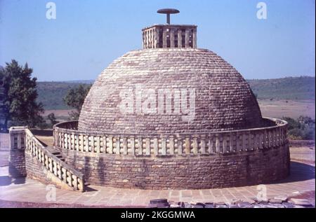 Sanchi ist ein buddhistischer Komplex, berühmt für seine große Stupa, auf einem Hügel in der Stadt Sanchi im Bezirk Raisen im Bundesstaat Madhya Pradesh, Indien. Die große Stupa in Sanchi ist eine der ältesten Steinbauten und ein wichtiges Denkmal der indischen Architektur. Es wurde ursprünglich vom maurischen Kaiser Ashoka dem Großen im 3.. Jahrhundert BCE in Auftrag gegeben. Es wurden vier kunstvoll geschnitzte Toranen (dekorative Tore) und eine Balustrade hinzugefügt, die die gesamte Struktur umgibt. Die Sanchi Stupa, die während der Mauryanzeit erbaut wurde, war aus Ziegeln. Sanchi Stupa steht für seine Bedeutung für das indische Kulturerbe. Stockfoto