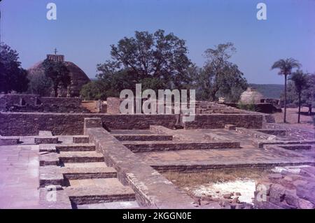 Sanchi ist ein buddhistischer Komplex, berühmt für seine große Stupa, auf einem Hügel in der Stadt Sanchi im Bezirk Raisen im Bundesstaat Madhya Pradesh, Indien. Die große Stupa in Sanchi ist eine der ältesten Steinbauten und ein wichtiges Denkmal der indischen Architektur. Es wurde ursprünglich vom maurischen Kaiser Ashoka dem Großen im 3.. Jahrhundert BCE in Auftrag gegeben. Es wurden vier kunstvoll geschnitzte Toranen (dekorative Tore) und eine Balustrade hinzugefügt, die die gesamte Struktur umgibt. Die Sanchi Stupa, die während der Mauryanzeit erbaut wurde, war aus Ziegeln. Sanchi Stupa steht für seine Bedeutung für das indische Kulturerbe. Stockfoto