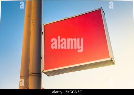 Leere rote Plastiktafel auf dem Postweg. Leere montierte Schilderplatte. Klare Beschilderung aus Plexiglas für Hotel- oder Ladeninformationen. Stockfoto