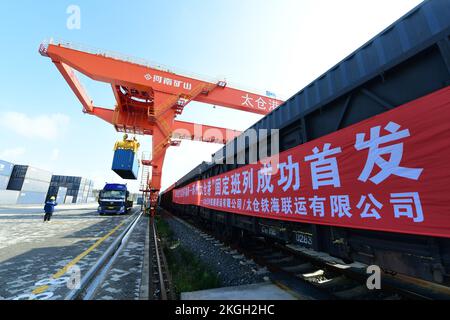 SUZHOU, CHINA - 23. NOVEMBER 2022 - Arbeiter heben Container für den ersten Güterzug von Pinghu südlich von Shenzhen zum Taicang Hafen in Suzhou, Osten Stockfoto