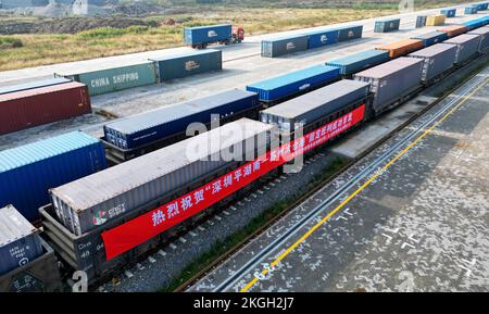 SUZHOU, CHINA - 23. NOVEMBER 2022 - Arbeiter heben Container für den ersten Güterzug von Pinghu südlich von Shenzhen zum Taicang Hafen in Suzhou, Osten Stockfoto