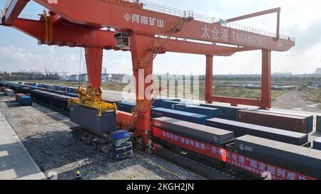 SUZHOU, CHINA - 23. NOVEMBER 2022 - Arbeiter heben Container für den ersten Güterzug von Pinghu südlich von Shenzhen zum Taicang Hafen in Suzhou, Osten Stockfoto