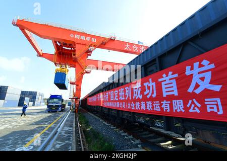 SUZHOU, CHINA - 23. NOVEMBER 2022 - Arbeiter heben Container für den ersten Güterzug von Pinghu südlich von Shenzhen zum Taicang Hafen in Suzhou, Osten Stockfoto