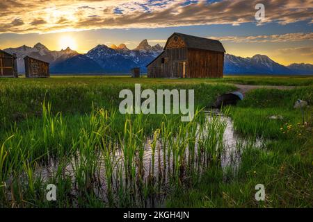 Sonnenuntergang über einer historischen Scheune in der Mormon Row im Grand Teton National Park, Wyoming Stockfoto