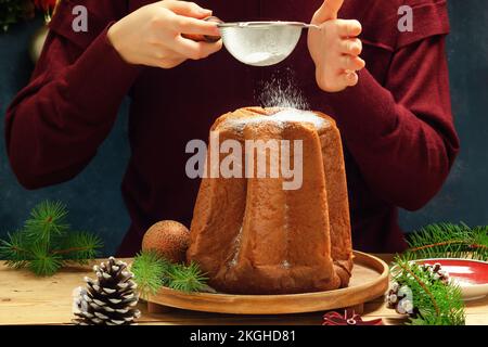 Pandoro: Italienisches weihnachtliches süßes Hefebrot auf festlichem Servierteller auf einem Holztisch. Stockfoto