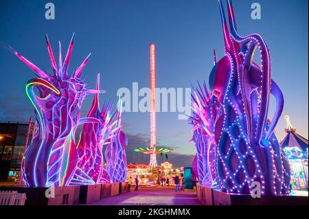 Star Flyer und Odyssey auf der Kirmes auf der Blackpool Promenade während der Weihnachtszeit 2022 Stockfoto