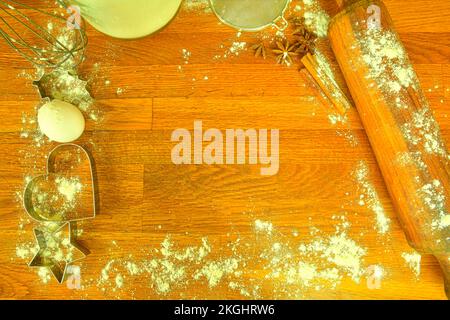 Zutaten zum Kochen von Weihnachtsgebäck. Küchenutensilien auf dunklem Hintergrund, Blick von oben. Speicherplatz kopieren Stockfoto