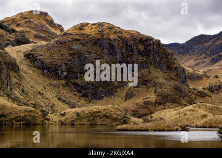 Eine schwarze Steinfelse und ein Gletschersee im Cajas-Nationalpark im Hochland der Anden von Ecuador, Cuenca und den tropischen Anden. Stockfoto