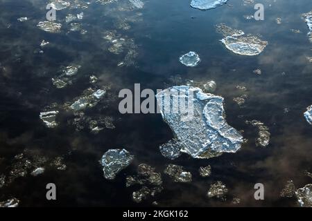 Schmelzendes Eis, das auf der Wasseroberfläche fließt. Eisdrift auf dem Fluss. Globale Erwärmung. Stockfoto