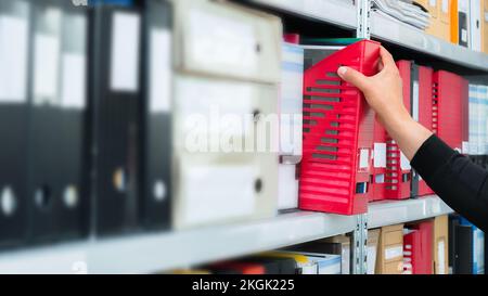 Mans hand Kommissionierung ein leeres blind Ordner mit Dateien aus dem Regal. Archivierung, Stapel von Dokumenten im Büro oder der Library Stockfoto