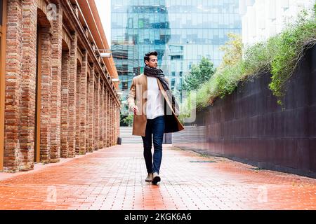 Schöner junger Mann in Winterkleidung, der durch die Stadt spazierengeht. Street Photo Konzept. Stockfoto