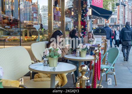 London - November 2022: High Street Kensington, W8 West London - Leute sitzen vor dem Café Concerto Stockfoto