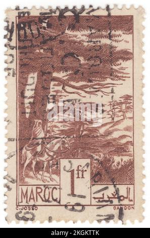 FRANZÖSISCH-MAROKKO - 1939: Ein 1 Franc Schokoladen-Briefmarken mit Zedern (Juniperus oxycedrus, im Allgemeinen Cade genannt, Wacholderbeere, Wacholderbeere, Zwergzwerge, Zwergzeder, Oder scharfe Zeder), ist eine im Mittelmeerraum einheimische Wacholderart, von Algerien und Portugal, von Norden bis Südfrankreich, von Osten bis zum westlichen Iran und von Süden bis Libanon und Israel, die auf einer Vielzahl von felsigen Gebieten vom Meeresspiegel bis zu 1.600 m Höhe wächst. Die spezifische Epithet-Oxycedrus bedeutet „Harfenzeder“, und diese Art könnte die ursprüngliche Zeder oder zedrus der antiken Griechen gewesen sein Stockfoto