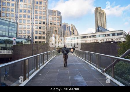 London, Großbritannien. 23.. November 2022 Ein Besucher geht über die Fußgängerbrücke zum Museum of London. Das Museum of London wird im Dezember 2022 geschlossen, da es sich auf den Umzug von seinem derzeitigen Standort an der Londoner Mauer zum Smithfield Market vorbereitet. Das neue London Museum soll 2026 eröffnet werden. Kredit: Vuk Valcic/Alamy Live News Stockfoto