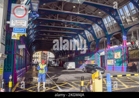 London, Großbritannien. 23.. November 2022 Ein Arbeiter reinigt den Eingang und die Lieferhalle am Smithfield Market. Das Museum of London wird im Dezember 2022 geschlossen, da es sich auf den Umzug von seinem derzeitigen Standort an der London Wall zum Smithfield Meat Market vorbereitet, der nach Dagenham verlegt wird. Das neue London Museum soll 2026 eröffnet werden. Kredit: Vuk Valcic/Alamy Live News Stockfoto