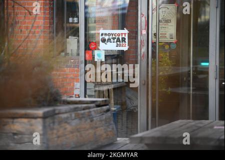 23. November 2022, Hamburg: "Boykott Qatar 2022" steht auf einem Poster an der Eingangstür eines noch geschlossenen Pubs in der St. Pauli Bezirk. In Hamburg gibt es keine offizielle öffentliche Zuschauerschaft für die aktuelle Weltmeisterschaft, und zahlreiche Pubs und Bars verzichten ebenfalls auf die Übertragung der Spiele. Foto: Jonas Walzberg/dpa - WICHTIGER HINWEIS: Gemäß den Anforderungen der DFL Deutsche Fußball Liga und des DFB Deutscher Fußball-Bund ist es verboten, im Stadion aufgenommene Fotos und/oder das Spiel in Form von Sequenzbildern und/oder videoähnlichen Fotoserien zu verwenden oder verwenden zu lassen. Stockfoto