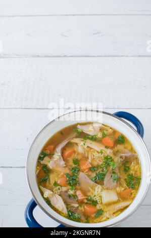 Topf mit Hühnchen-Nudelsuppe isoliert auf weißem Hintergrund mit Kopierbereich. Flach liegend – vertikales Bild Stockfoto