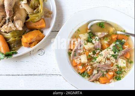 Hähnchensuppe mit alphabetischer Pasta auf hellem Holztisch Stockfoto